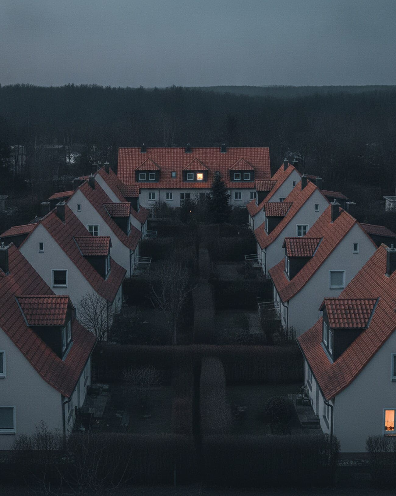 Reihe von Giebeldächern über einem Wohnquartier in der Abenddämmerung
