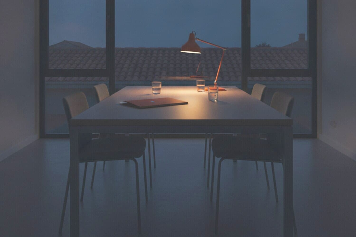 Leerer Besprechungstisch in einem Büro, Fenster mit Abendlicht dahinter
